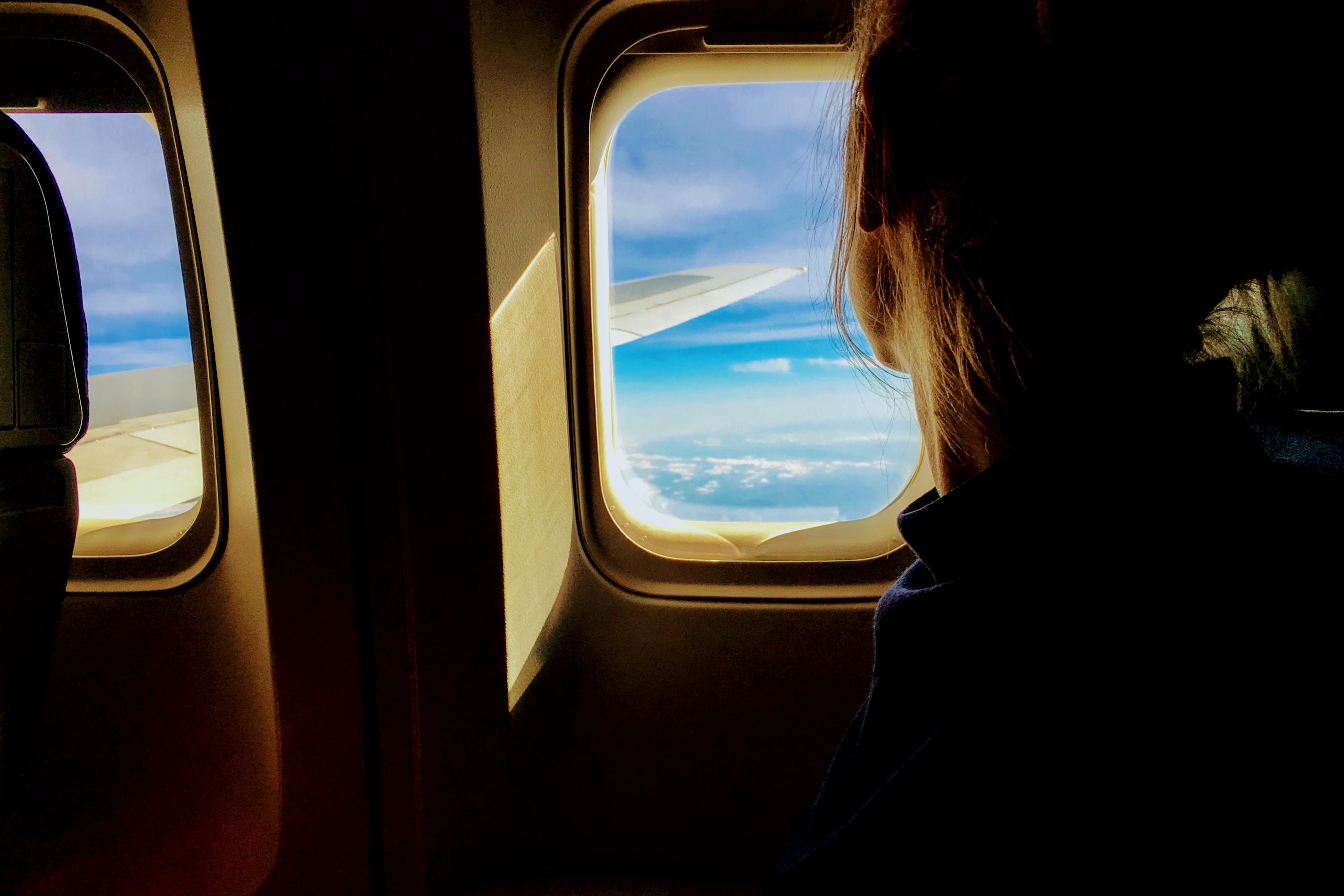 Wanderlust traveler looking out the window of an airplane